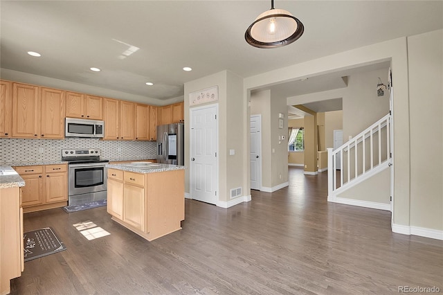 kitchen with a center island, stainless steel appliances, tasteful backsplash, visible vents, and dark wood-type flooring