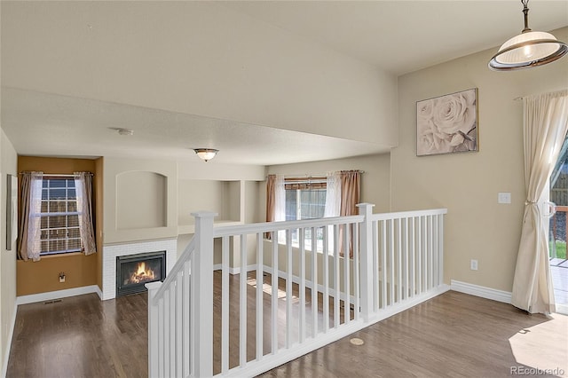 hall featuring a wealth of natural light, baseboards, and wood finished floors