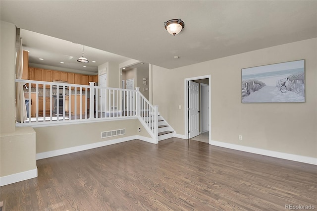 spare room with visible vents, baseboards, wood finished floors, stairs, and recessed lighting