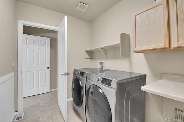 laundry area featuring visible vents, independent washer and dryer, and cabinet space