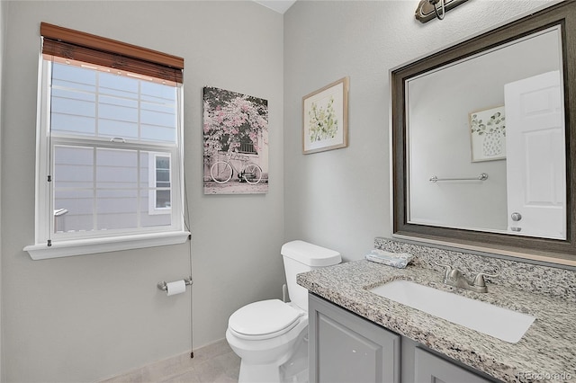 bathroom featuring tile patterned flooring, vanity, and toilet