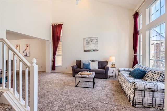 carpeted living room with a towering ceiling