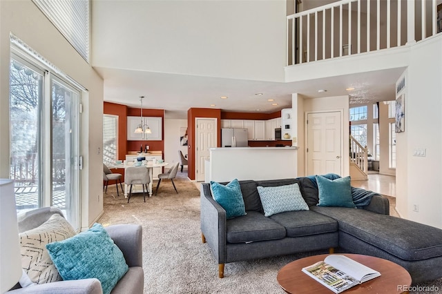 living room with a towering ceiling and light colored carpet