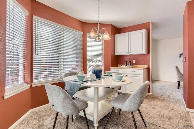 carpeted dining room with an inviting chandelier