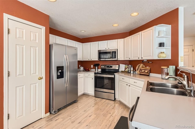 kitchen featuring appliances with stainless steel finishes, sink, and white cabinets