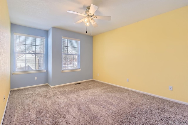 carpeted spare room with ceiling fan