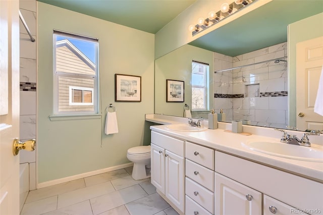 bathroom with tiled shower, vanity, and toilet