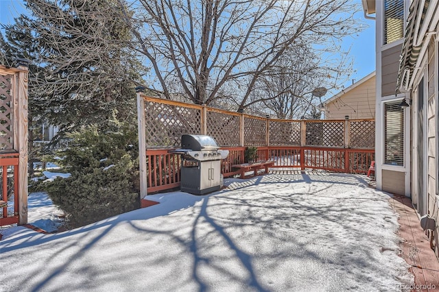 snow covered patio with a grill