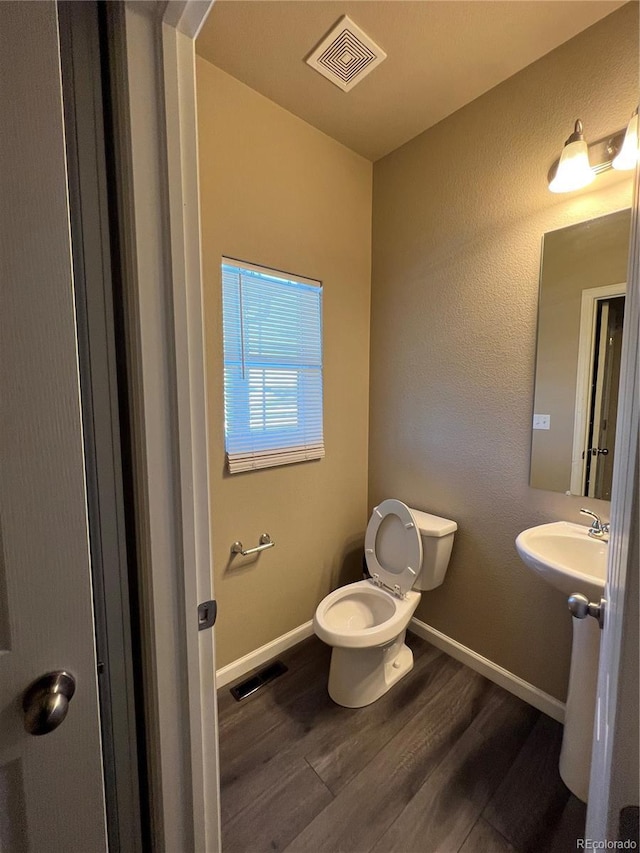 bathroom featuring hardwood / wood-style flooring, toilet, and sink