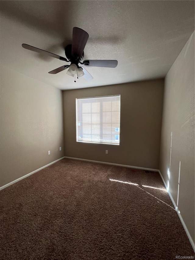 carpeted spare room featuring ceiling fan and a textured ceiling