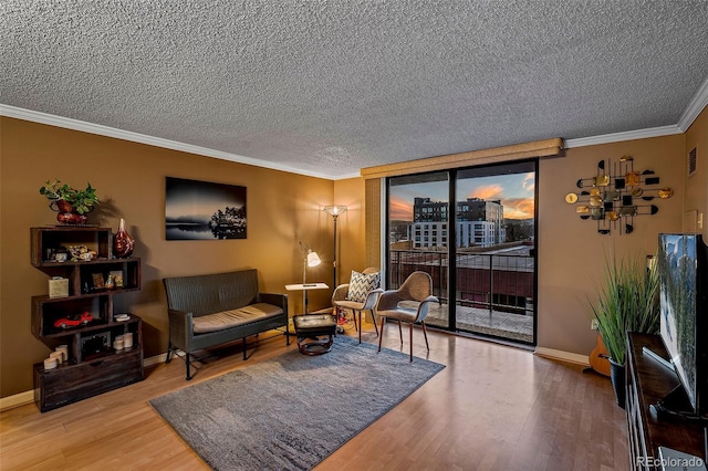 living area with hardwood / wood-style floors, expansive windows, crown molding, and a textured ceiling