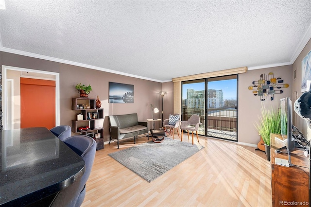 living room featuring crown molding, wood finished floors, baseboards, and a textured ceiling