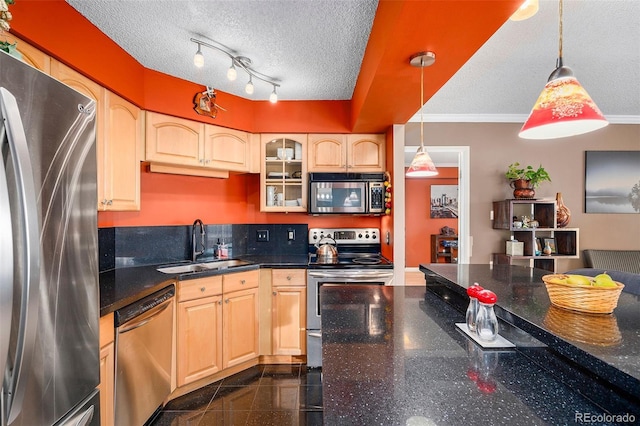 kitchen featuring a textured ceiling, appliances with stainless steel finishes, hanging light fixtures, and sink