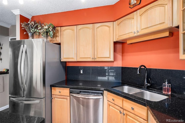 kitchen with a textured ceiling, light brown cabinets, stainless steel appliances, decorative backsplash, and sink