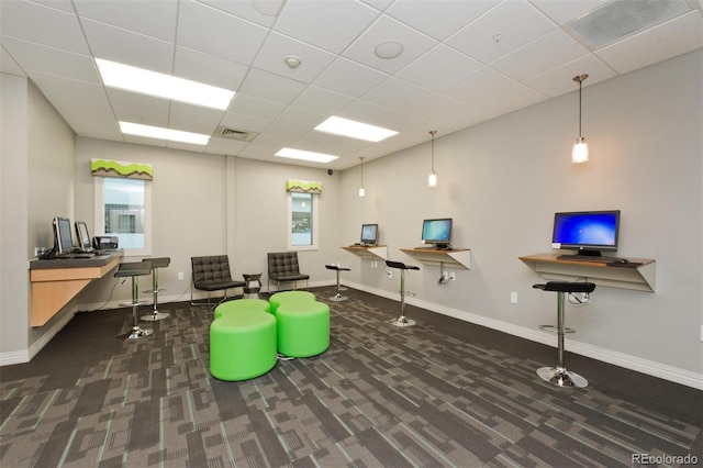 interior space with a drop ceiling, baseboards, visible vents, and carpet floors