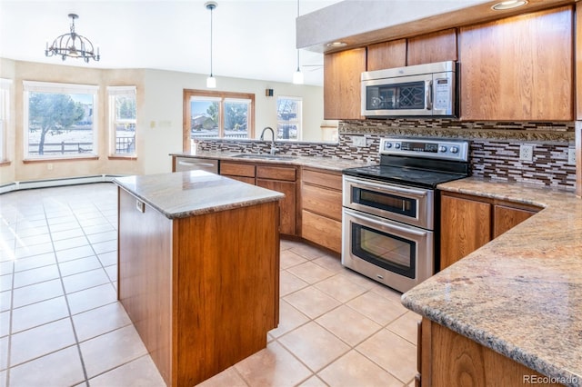 kitchen featuring appliances with stainless steel finishes, decorative light fixtures, sink, light tile patterned floors, and decorative backsplash