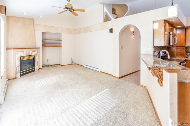 carpeted living room with ceiling fan, high vaulted ceiling, baseboard heating, and a fireplace