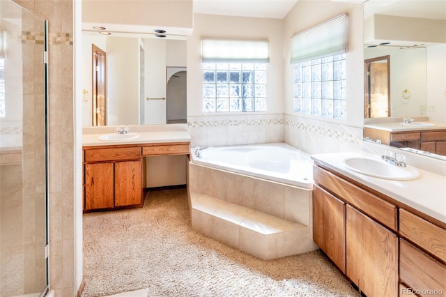 bathroom with tiled bath and vanity