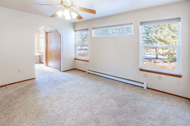 unfurnished room featuring ceiling fan, a healthy amount of sunlight, a baseboard heating unit, and light colored carpet