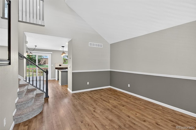 4535 Hunterwood Dr, Highlands Ranch, CO 80130 - empty room with wood finished floors, stairway, and high vaulted ceiling