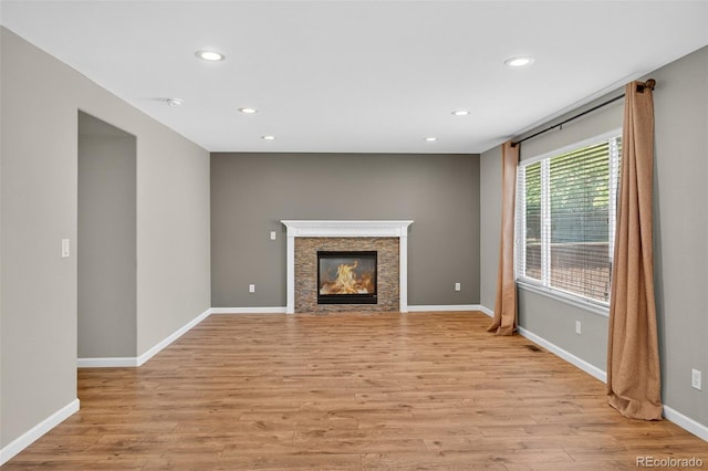 4535 Hunterwood Dr, Highlands Ranch, CO 80130 - unfurnished living room featuring light wood finished floors, recessed lighting, and a stone fireplace