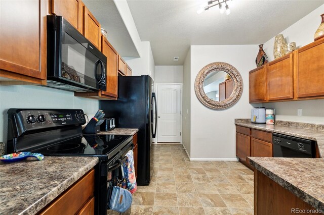 5302 Canadian Rose Vw, Colorado Springs, CO 80916 - kitchen with black appliances, baseboards, brown cabinets, and stone finish floors