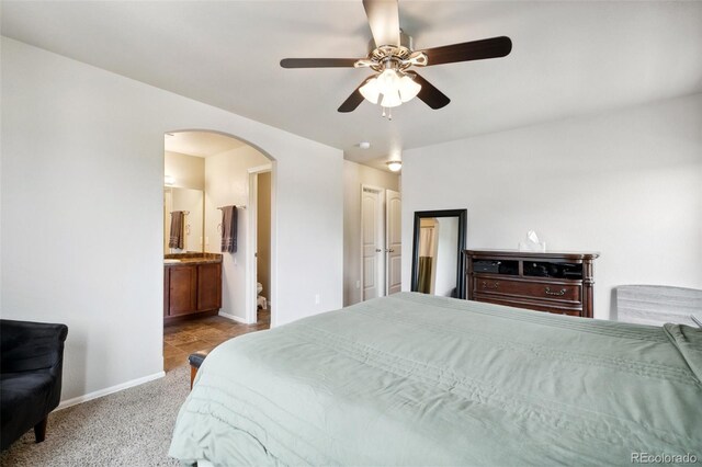 5302 Canadian Rose Vw, Colorado Springs, CO 80916 - bedroom with arched walkways, baseboards, light colored carpet, a ceiling fan, and ensuite bathroom
