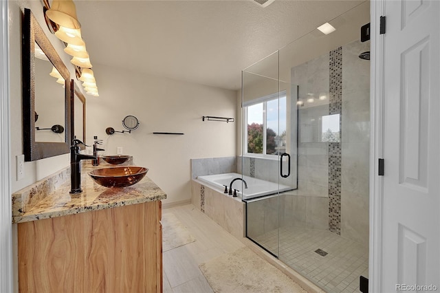 bathroom with vanity, plus walk in shower, tile patterned flooring, and a textured ceiling