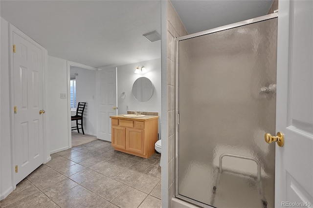 bathroom featuring walk in shower, vanity, tile patterned flooring, and toilet