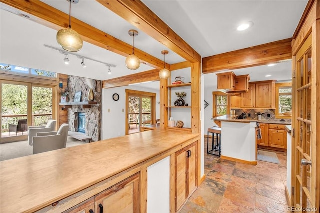 32217 Buffalo Park Rd, Evergreen, CO 80439 - kitchen with plenty of natural light, a stone fireplace, hanging light fixtures, light stone finish flooring, and recessed lighting