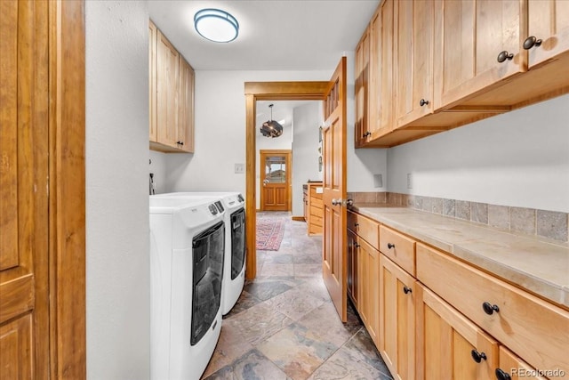 32217 Buffalo Park Rd, Evergreen, CO 80439 - laundry area with washing machine and clothes dryer, cabinet space, and light stone finish flooring