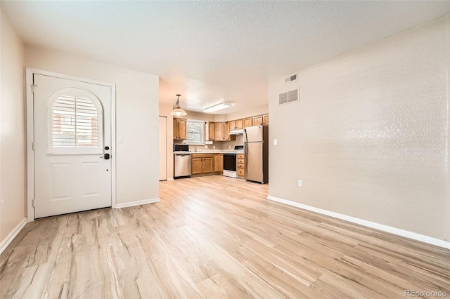 1648 S Cole St Unit A2, Lakewood, CO 80228 - unfurnished living room with light wood-style flooring, plenty of natural light, and baseboards