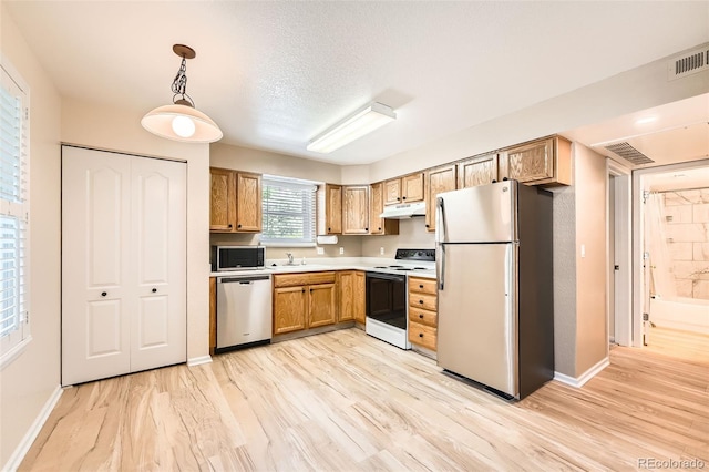 1648 S Cole St Unit A2, Lakewood, CO 80228 - kitchen with stainless steel appliances, under cabinet range hood, light wood-type flooring, and baseboards