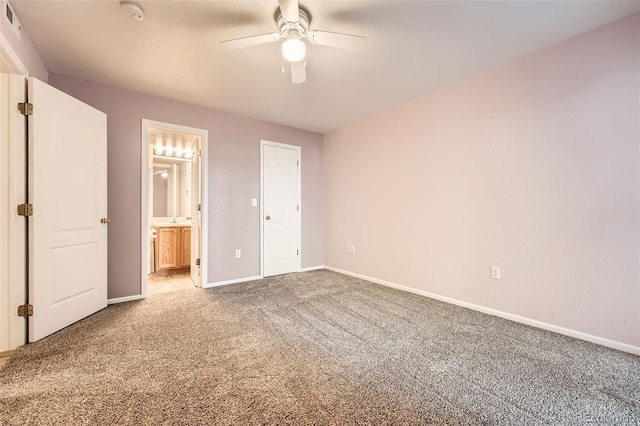 1648 S Cole St Unit A2, Lakewood, CO 80228 - unfurnished bedroom featuring light carpet, baseboards, connected bathroom, and ceiling fan