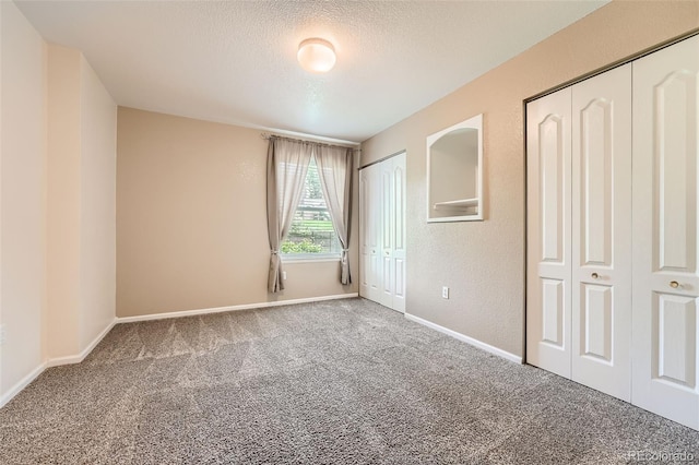 1648 S Cole St Unit A2, Lakewood, CO 80228 - unfurnished bedroom with carpet flooring, two closets, a textured ceiling, and baseboards