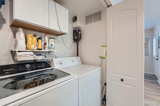 1648 S Cole St Unit A2, Lakewood, CO 80228 - laundry room featuring cabinet space, washing machine and dryer, and light wood-style flooring