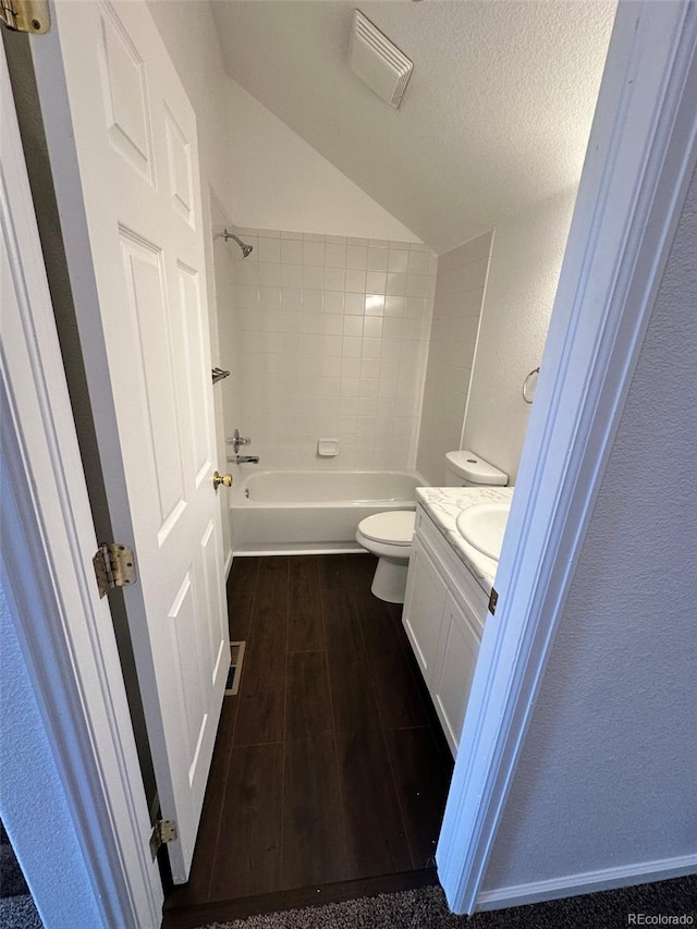 15555 E 40th Ave Unit 11, Denver, CO 80239 - bathroom featuring vanity, vaulted ceiling,  shower combination, wood finished floors, and a textured wall