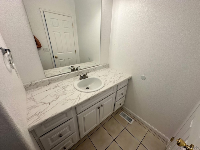15555 E 40th Ave Unit 11, Denver, CO 80239 - bathroom with vanity, tile patterned flooring, and a textured wall