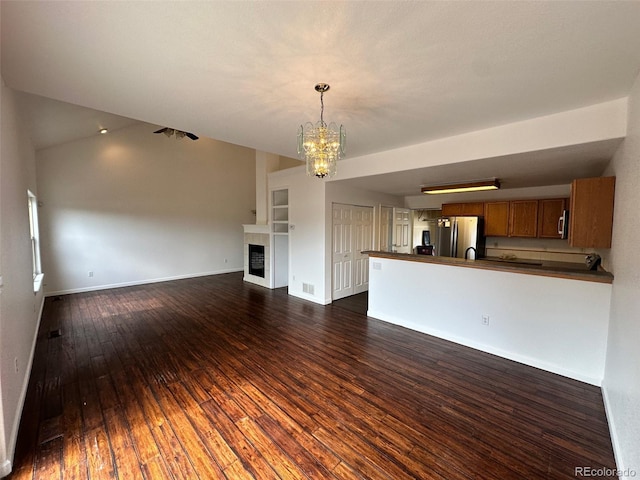 15555 E 40th Ave Unit 11, Denver, CO 80239 - unfurnished living room with a chandelier, dark wood-style flooring, and a tile fireplace