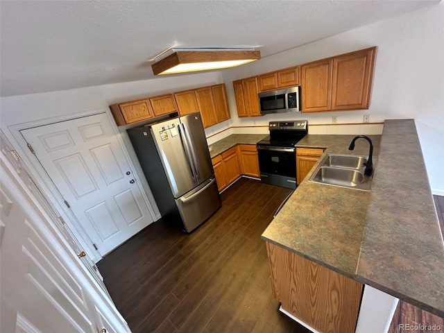 15555 E 40th Ave Unit 11, Denver, CO 80239 - kitchen featuring appliances with stainless steel finishes, dark wood-style flooring, dark countertops, brown cabinetry, and a textured ceiling