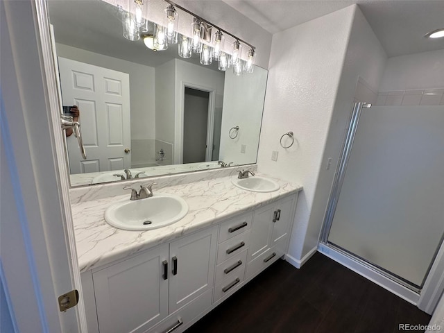 15555 E 40th Ave Unit 11, Denver, CO 80239 - bathroom featuring double vanity, wood finished floors, and a stall shower