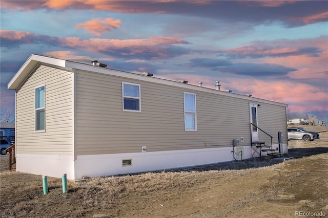 property exterior at dusk featuring entry steps and crawl space