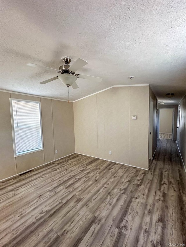 spare room featuring a textured ceiling, wood finished floors, and a ceiling fan