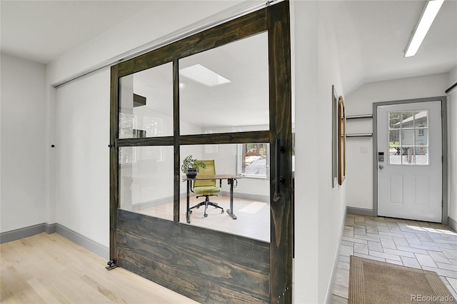 10887 Goodheart Ave, Conifer, CO 80433 - doorway to outside featuring plenty of natural light, a desk, vaulted ceiling, and baseboards