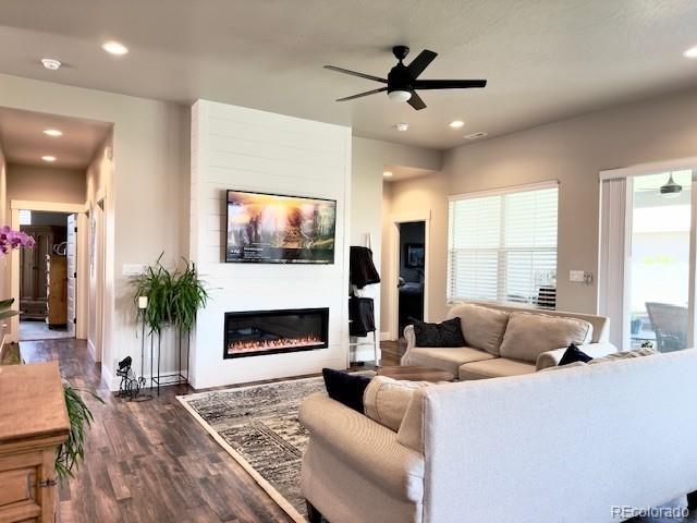 734 Flamecrest Dr, Fruita, CO 81521 - living area with ceiling fan, wood finished floors, a glass covered fireplace, and recessed lighting
