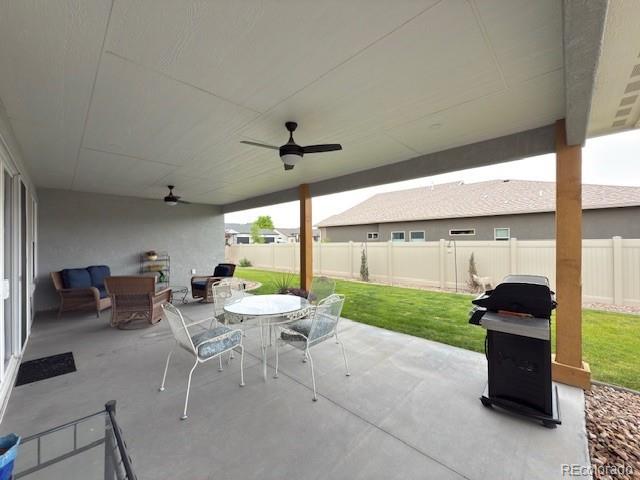 734 Flamecrest Dr, Fruita, CO 81521 - fenced backyard with outdoor dining area, ceiling fan, grilling area, and a patio