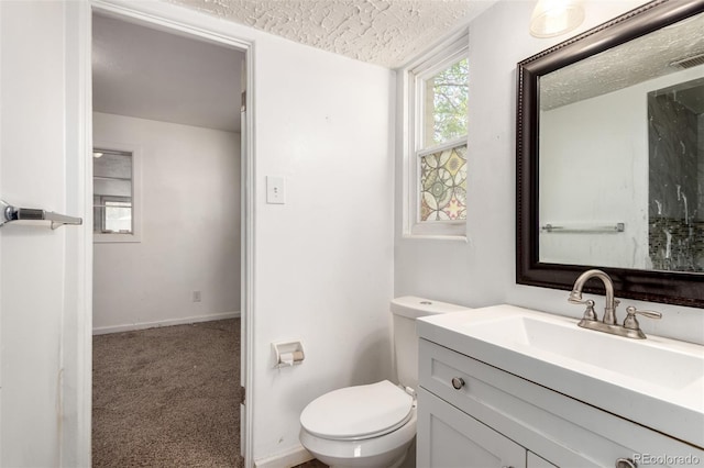 1151 Revere St, Aurora, CO 80011 - bathroom with vanity, toilet, a textured ceiling, and baseboards