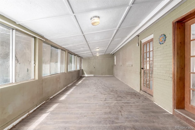 1151 Revere St, Aurora, CO 80011 - hallway with wood finished floors, wooden walls, and brick wall