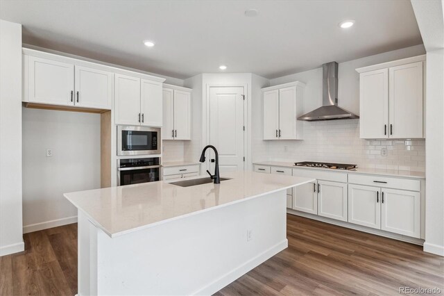8462 Eagle River St, Littleton, CO 80125 - kitchen featuring stainless steel appliances, white cabinetry, a sink, dark wood-style floors, and wall chimney range hood