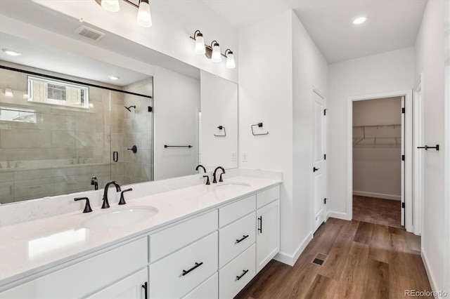 8462 Eagle River St, Littleton, CO 80125 - full bath with a spacious closet, a sink, a shower stall, and visible vents
